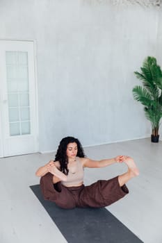 Stay at home fitness. Strong mature woman doing half bridge yoga pose, strengthening her abs muscles indoors, copy space. Fit senior woman working out in living room during covid isolation