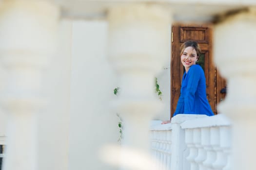 woman in blue clothes stands on the street at the front door