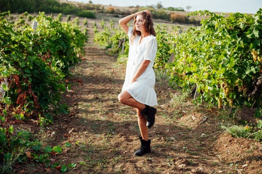 a woman in a white dress stands in the vineyards of country nature walk