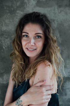 portrait of a woman in black dress against a gray wall