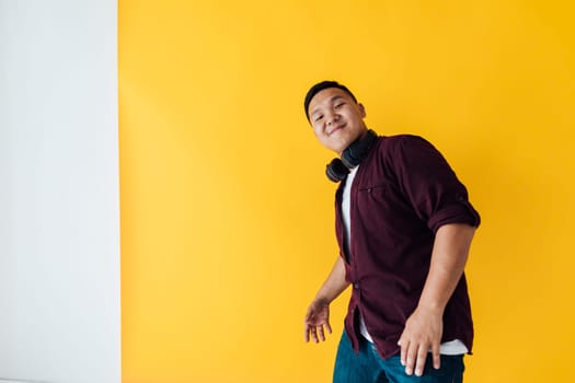 man with headphones dancing on a yellow background