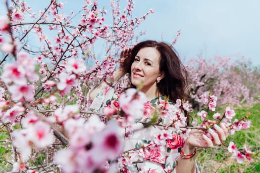 nature park spring woman stands in garden of flowering pink trees