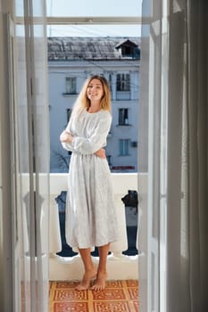 blonde stands on balcony in the apartment room