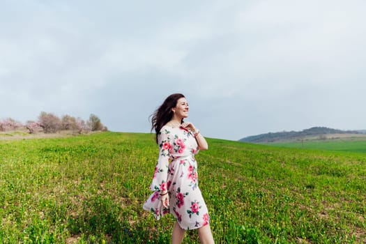 cheerful woman in green clearing on the street in a park in nature