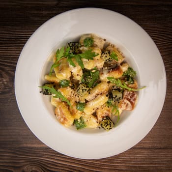 RECIPE FOR POTATO GNOCCHI WITH ROCKET SALAD PESTO AND CREAMY PARMESAN SAUCE. High quality photo