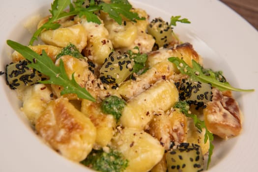 RECIPE FOR POTATO GNOCCHI WITH ROCKET SALAD PESTO AND CREAMY PARMESAN SAUCE. High quality photo