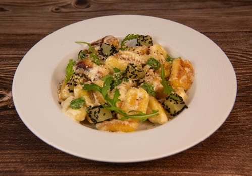 RECIPE FOR POTATO GNOCCHI WITH ROCKET SALAD PESTO AND CREAMY PARMESAN SAUCE. High quality photo