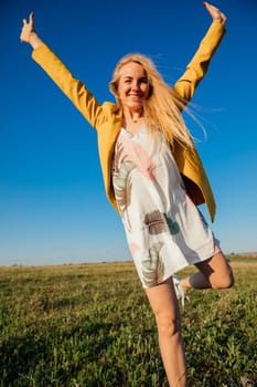 a walking journey a blonde woman walking in nature on green grass in a field