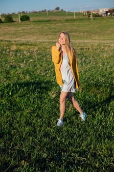 a walking journey a blonde woman walking in nature on green grass in a field