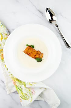 porridge with mint leaves and pieces of meat in sweet and sour sauce