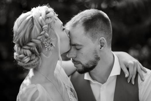 wedding walk of the bride and groom in a coniferous park in summer in elven accessories