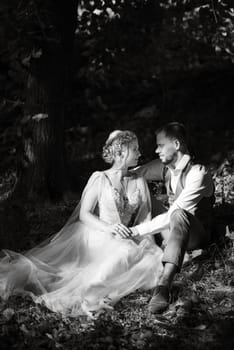 wedding walk of the bride and groom in a coniferous park in summer in elven accessories