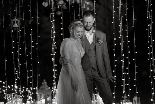 night wedding ceremony of the newlyweds in a country cottage on a green hill