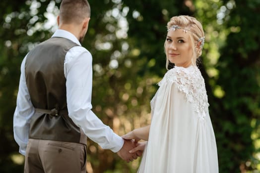 the first meeting of the bride and groom in wedding outfits in the park