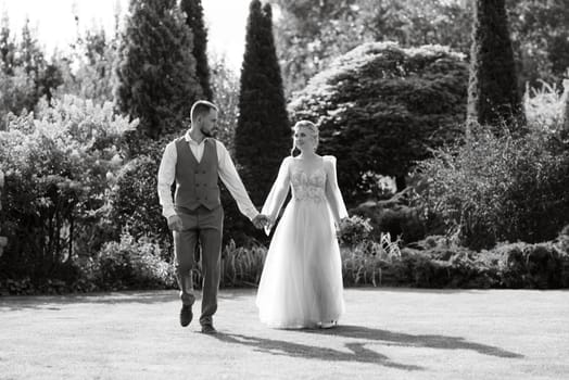 wedding walk of the bride and groom in a coniferous park in summer in elven accessories