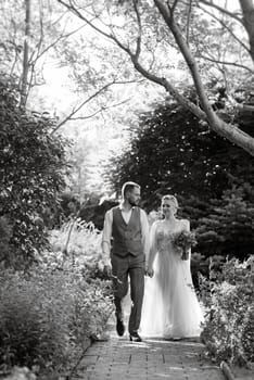 wedding walk of the bride and groom in a coniferous park in summer in elven accessories