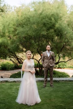 the first meeting of the bride and groom in wedding outfits in the park