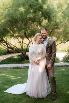 the first meeting of the bride and groom in wedding outfits in the park