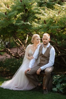 wedding walk of the bride and groom in a coniferous park in summer in elven accessories