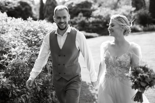 wedding walk of the bride and groom in a coniferous park in summer in elven accessories