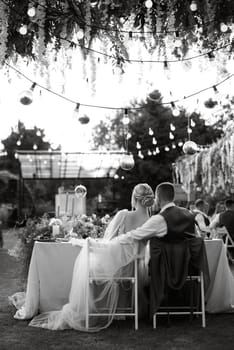 evening wedding family dinner in the forest with light bulbs and candles