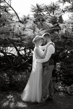 wedding walk of the bride and groom in a coniferous park in summer in elven accessories