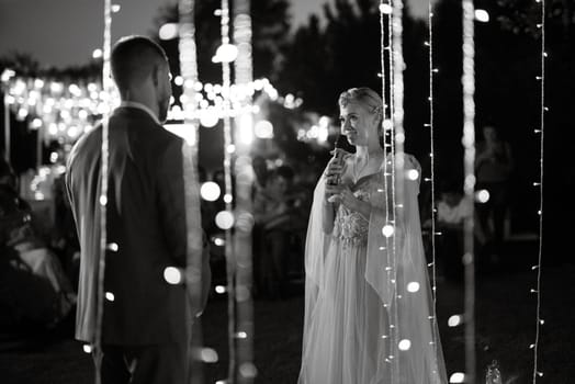 night wedding ceremony of the newlyweds in a country cottage on a green hill