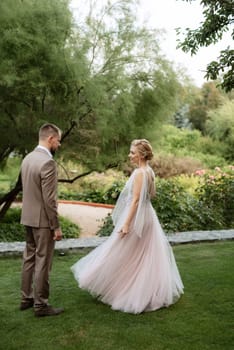 the first meeting of the bride and groom in wedding outfits in the park