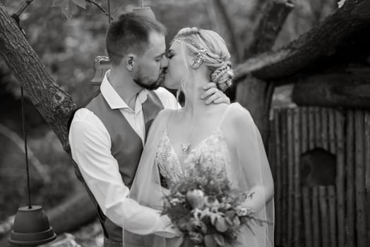 wedding walk of the bride and groom in a coniferous park in summer in elven accessories