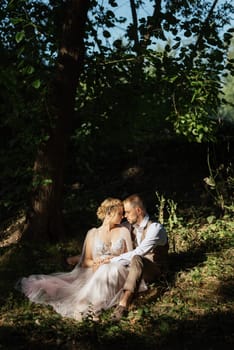 wedding walk of the bride and groom in a coniferous park in summer in elven accessories