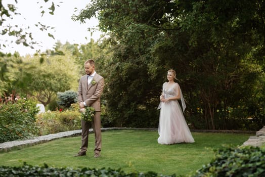 the first meeting of the bride and groom in wedding outfits in the park