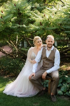 wedding walk of the bride and groom in a coniferous park in summer in elven accessories