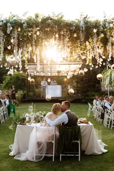 evening wedding family dinner in the forest with light bulbs and candles