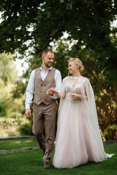 the first meeting of the bride and groom in wedding outfits in the park