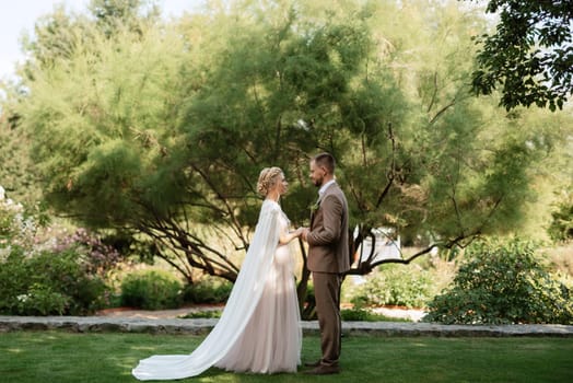 the first meeting of the bride and groom in wedding outfits in the park