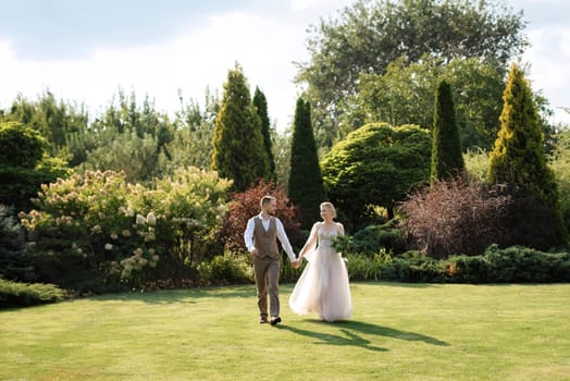 wedding walk of the bride and groom in a coniferous park in summer in elven accessories