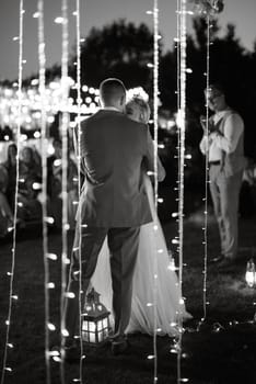 night wedding ceremony of the newlyweds in a country cottage on a green hill