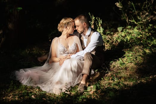 wedding walk of the bride and groom in a coniferous park in summer in elven accessories