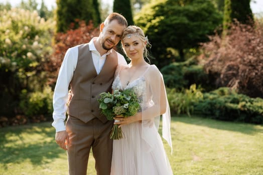 wedding walk of the bride and groom in a coniferous park in summer in elven accessories