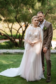 the first meeting of the bride and groom in wedding outfits in the park