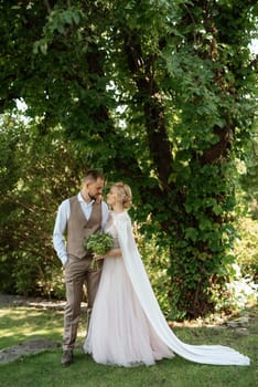 the first meeting of the bride and groom in wedding outfits in the park