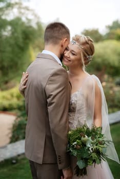 the first meeting of the bride and groom in wedding outfits in the park