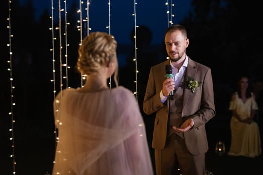 night wedding ceremony of the newlyweds in a country cottage on a green hill