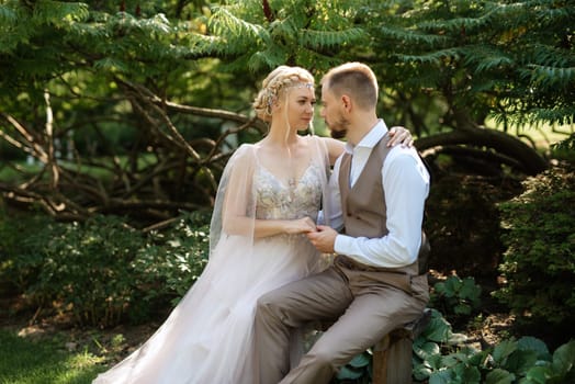 wedding walk of the bride and groom in a coniferous park in summer in elven accessories