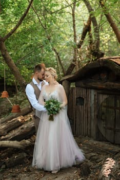 wedding walk of the bride and groom in a coniferous park in summer in elven accessories