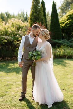 wedding walk of the bride and groom in a coniferous park in summer in elven accessories