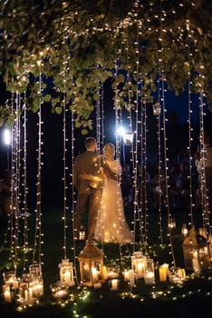 night wedding ceremony of the newlyweds in a country cottage on a green hill