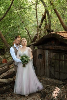 wedding walk of the bride and groom in a coniferous park in summer in elven accessories