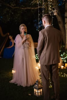 night wedding ceremony of the newlyweds in a country cottage on a green hill