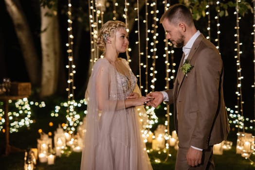 night wedding ceremony of the newlyweds in a country cottage on a green hill